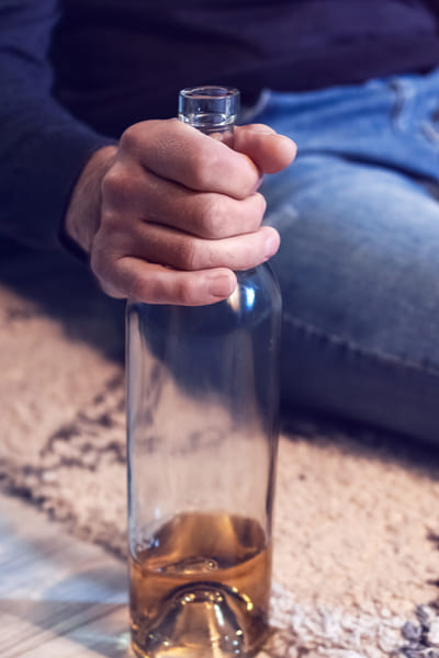 Алкоголик с бутылкой в руке